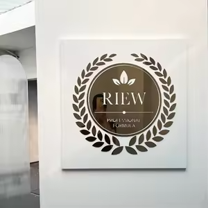 Silver round logo plaque with RIW branding and wreath